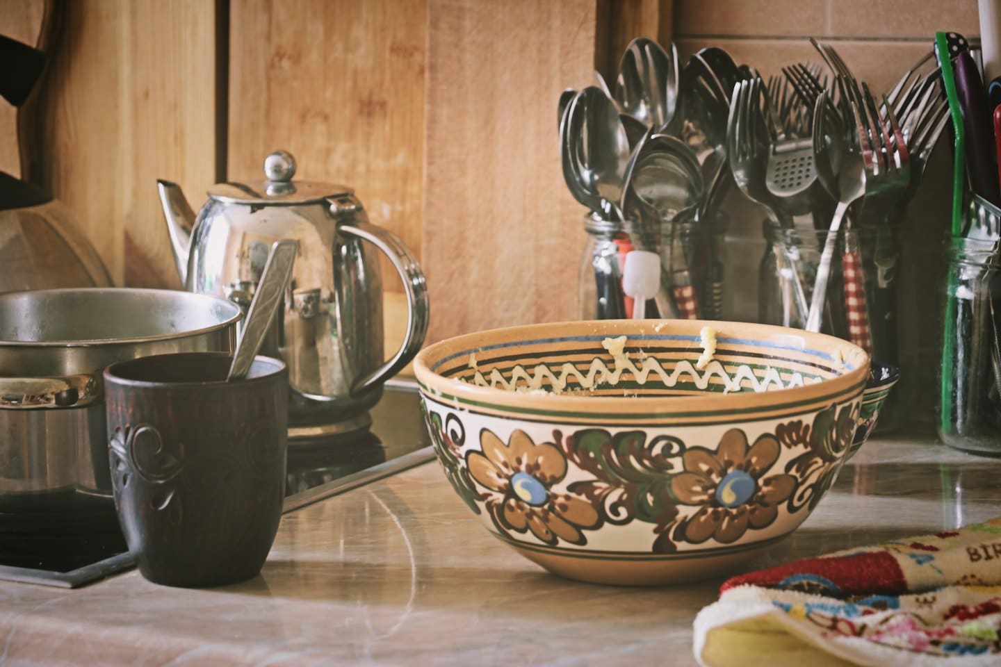Ceramic bowl and teapot sitting on a rustic wooden counter.
